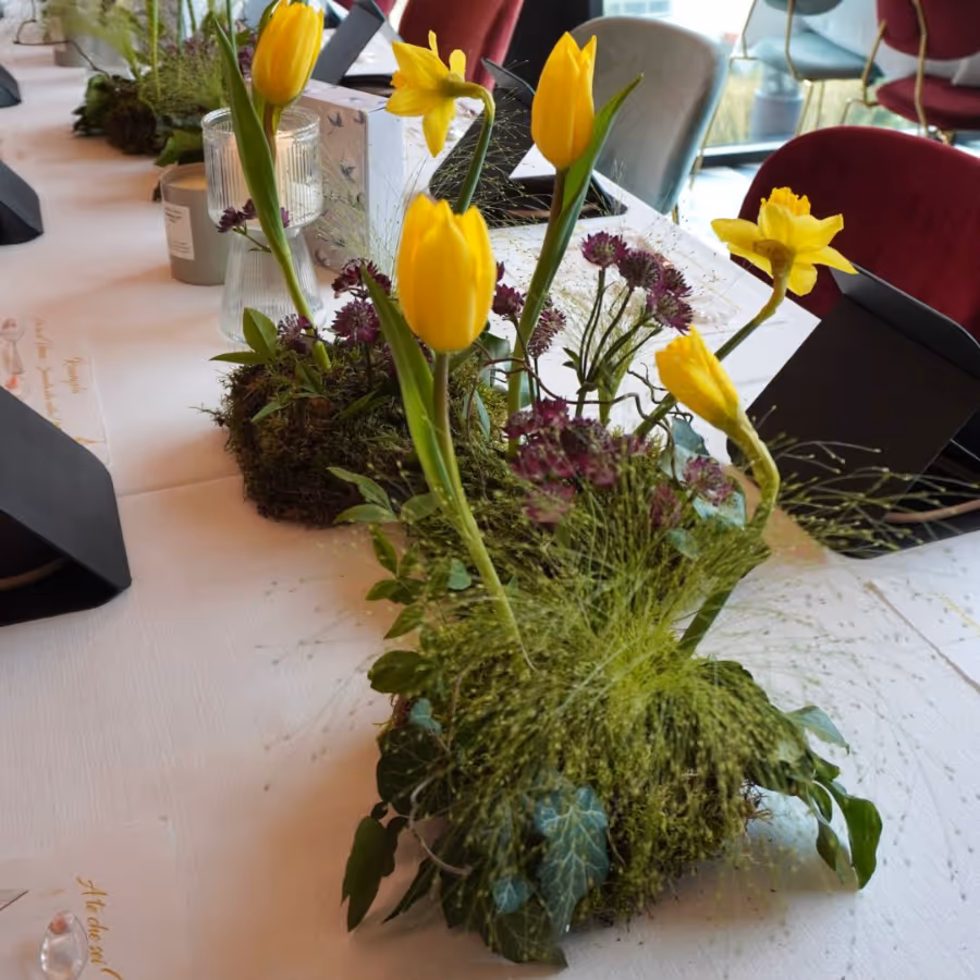 Composizione floreale su tavolo da lavoro con fiori freschi, creazione artigianale per allestimenti floreali