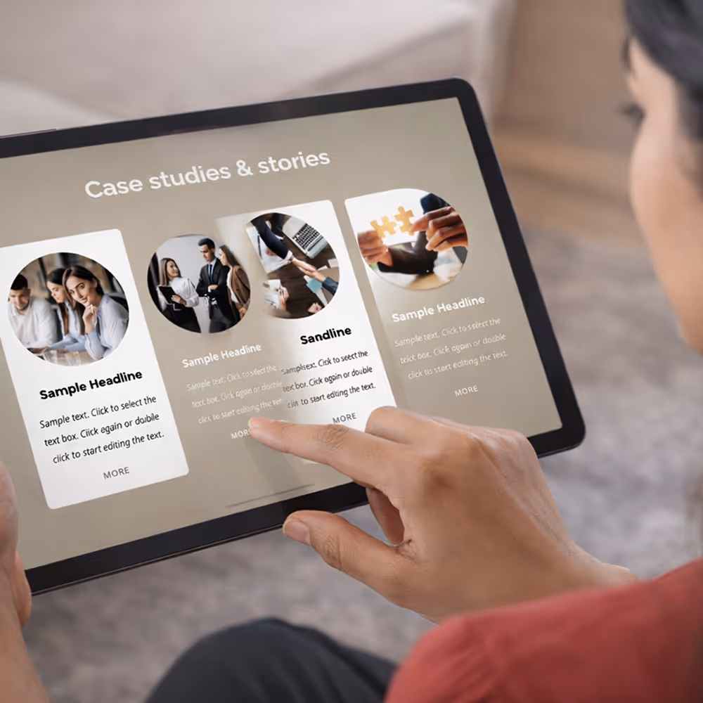 Person using a tablet displaying a digital interface with case studies and stories in a grid layout.