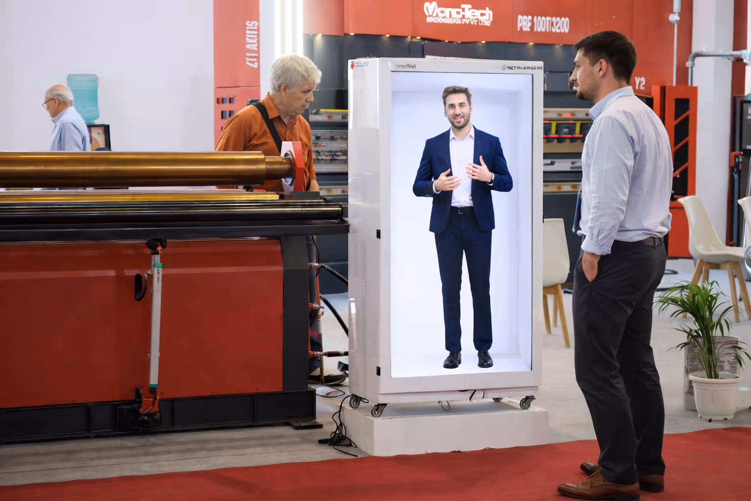 Man in business attire interacting with a life-sized hologram or digital display of another man in a suit at a technology exhibition.