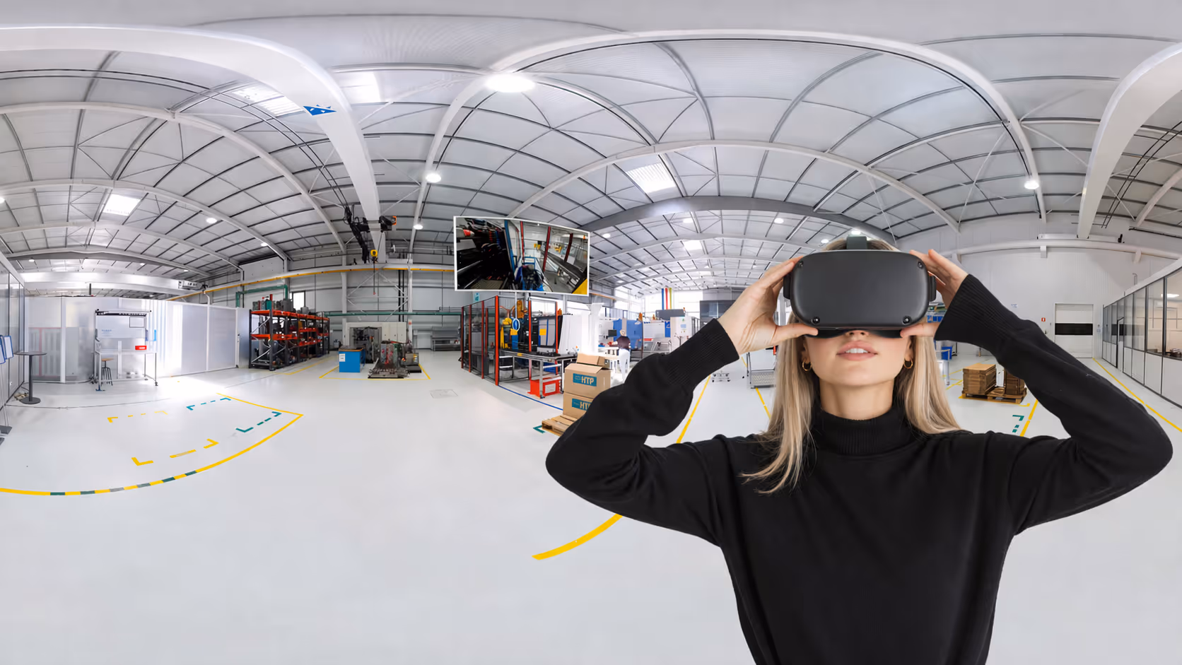 Woman wearing a virtual reality headset inside a spacious, modern industrial workshop.