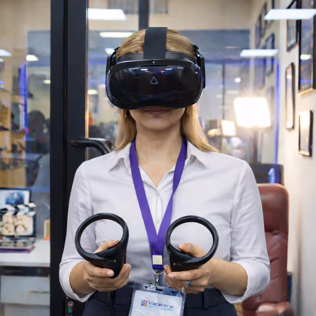 Woman wearing a virtual reality headset and holding two VR controllers in an office environment.