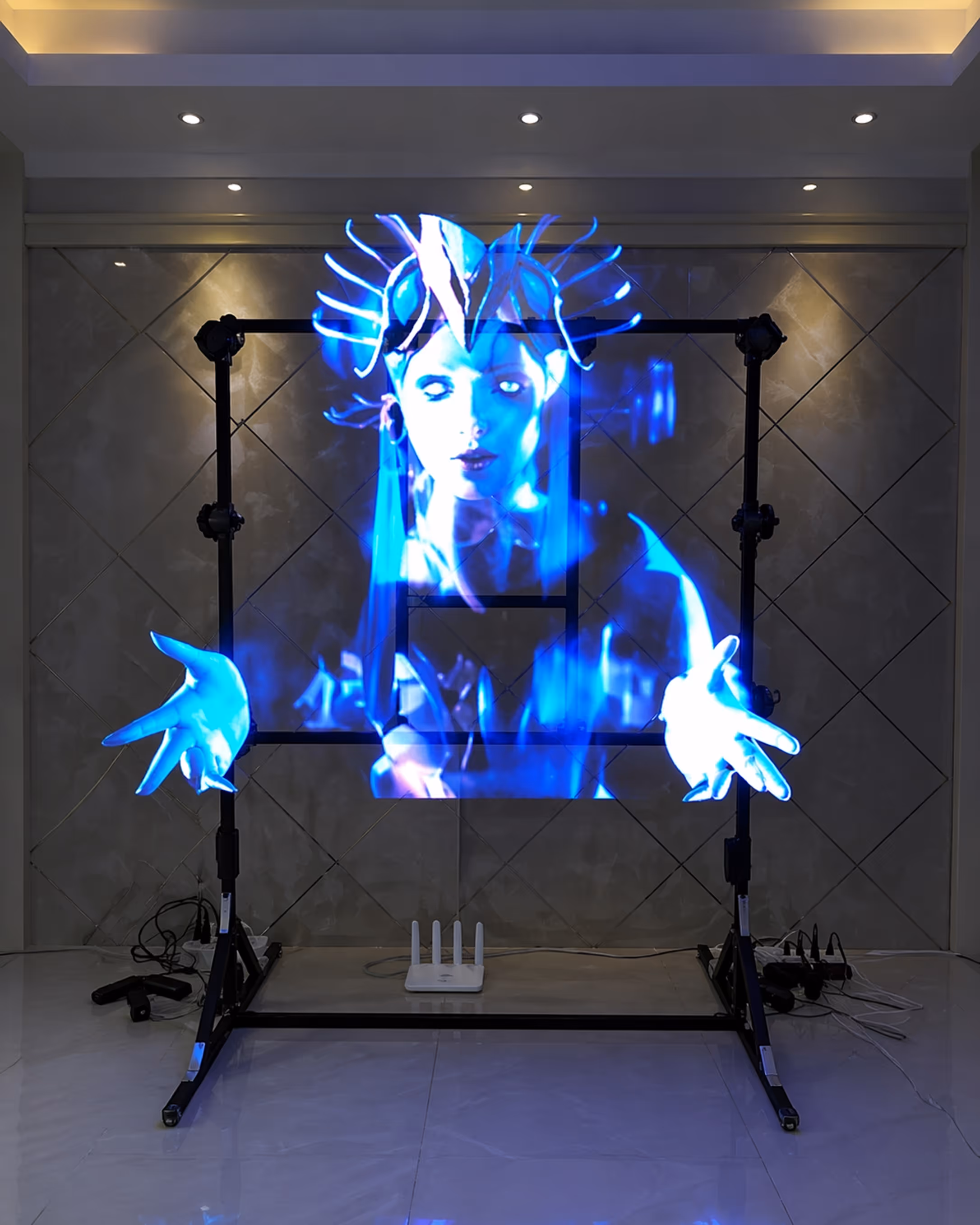 Holographic blue projection of a female figure with outstretched hands displayed on a black metal frame indoors.