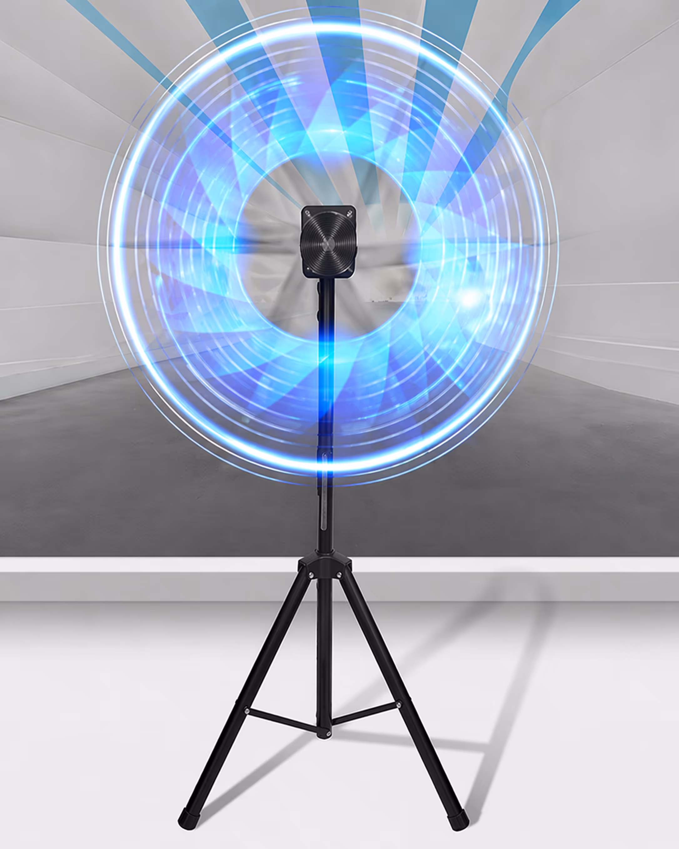 Black tripod standing fan with blue circular motion blur effect on the blades in an empty white and grey room.