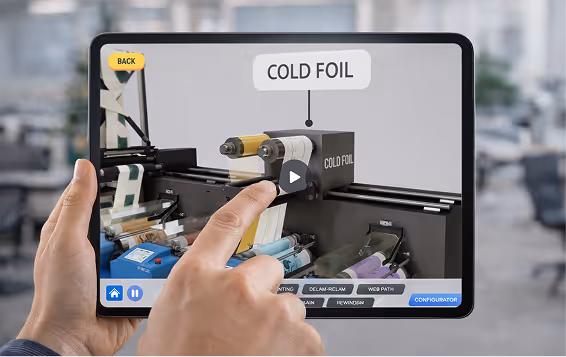 Hands holding a tablet showing a video paused on a cold foil printing machine.