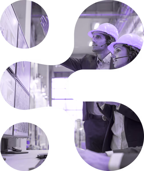 Two engineers wearing helmets and headsets pointing at a wall of documents in an industrial setting.