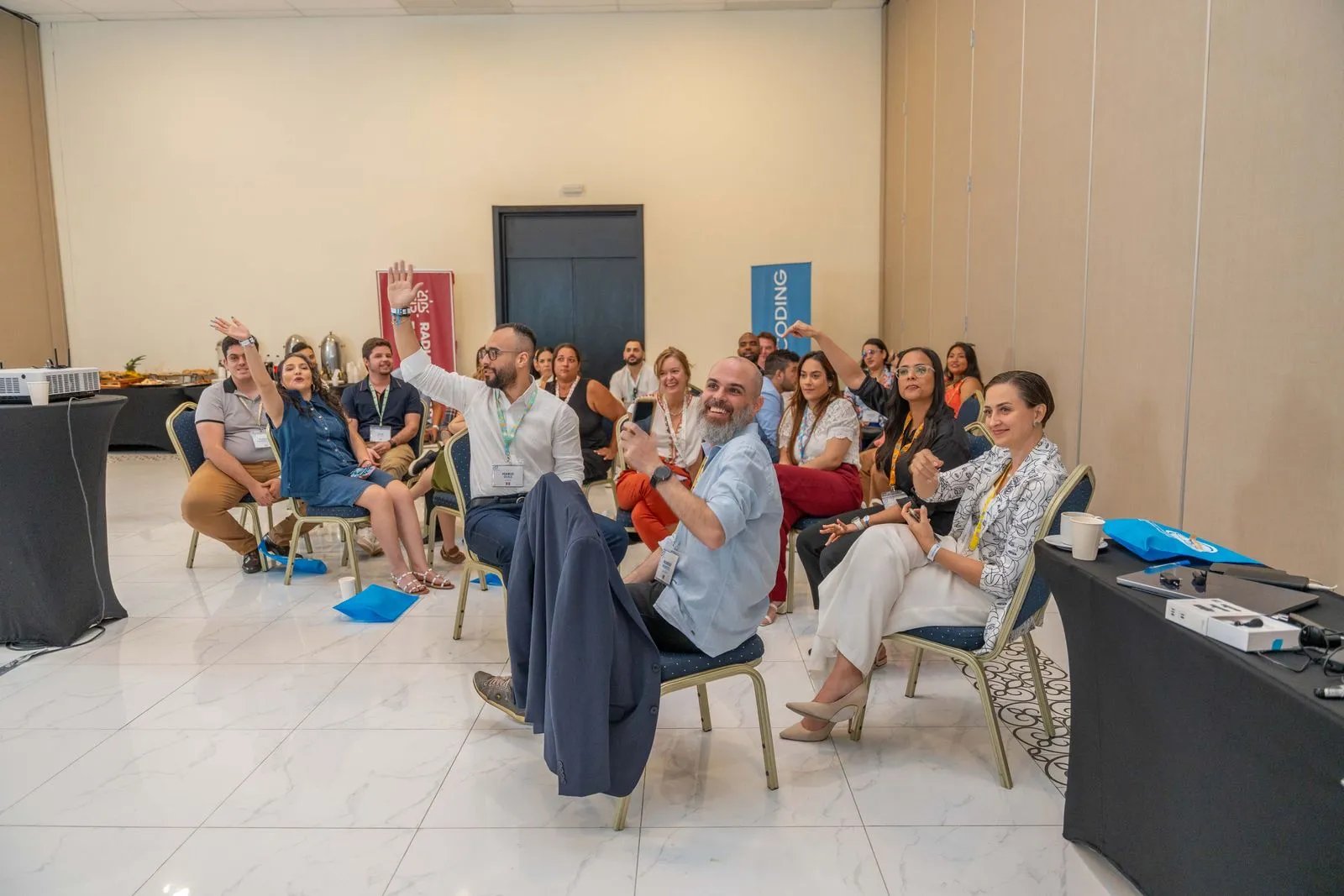 Team members raising hands during a company workshop