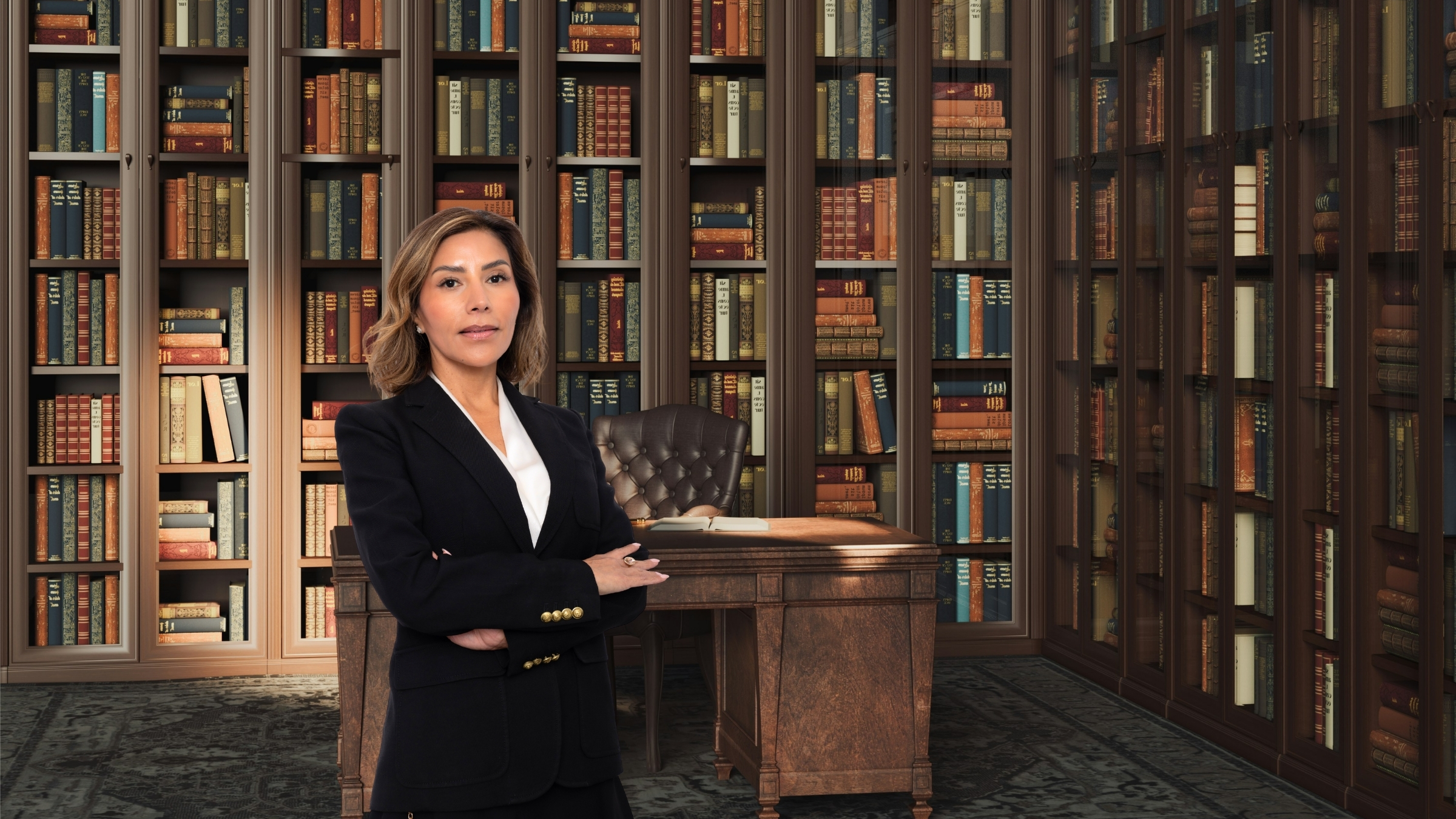 Esli Frias standing with her arms crossed in front of a bookshelf-lined office.