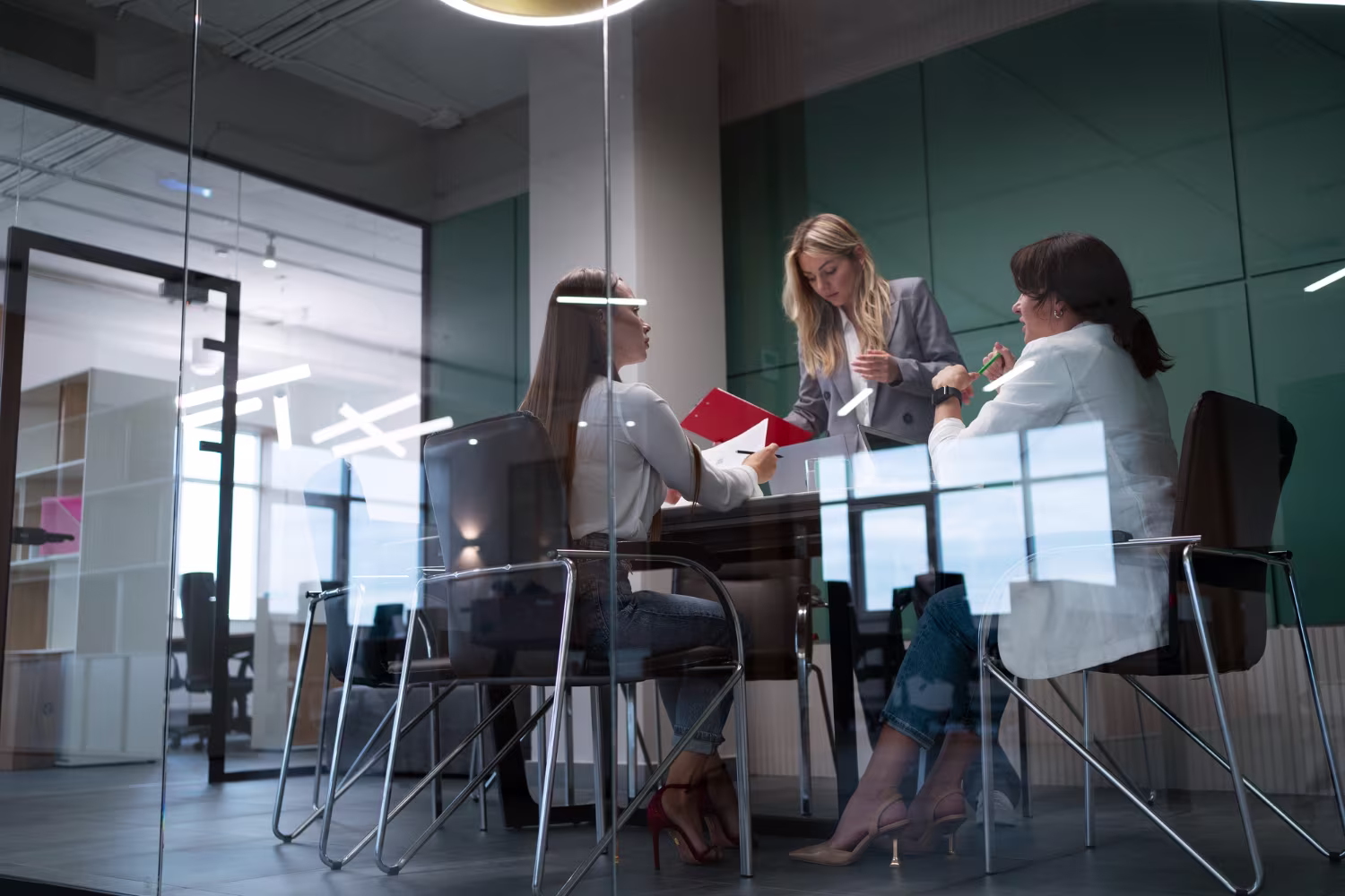 Finance team reviewing documents together in a modern glass office