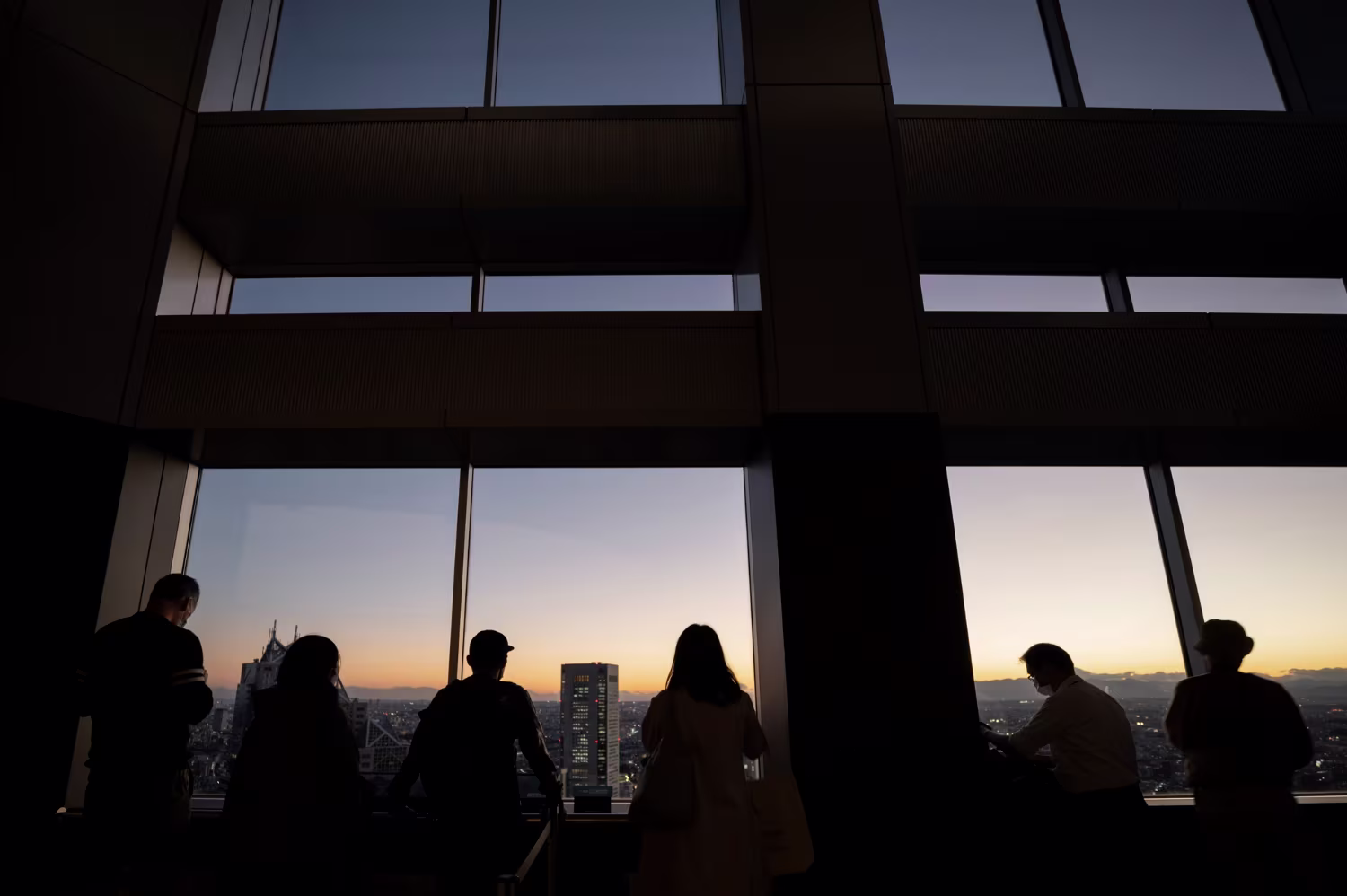 Business professionals silhouetted against a city skyline at dusk