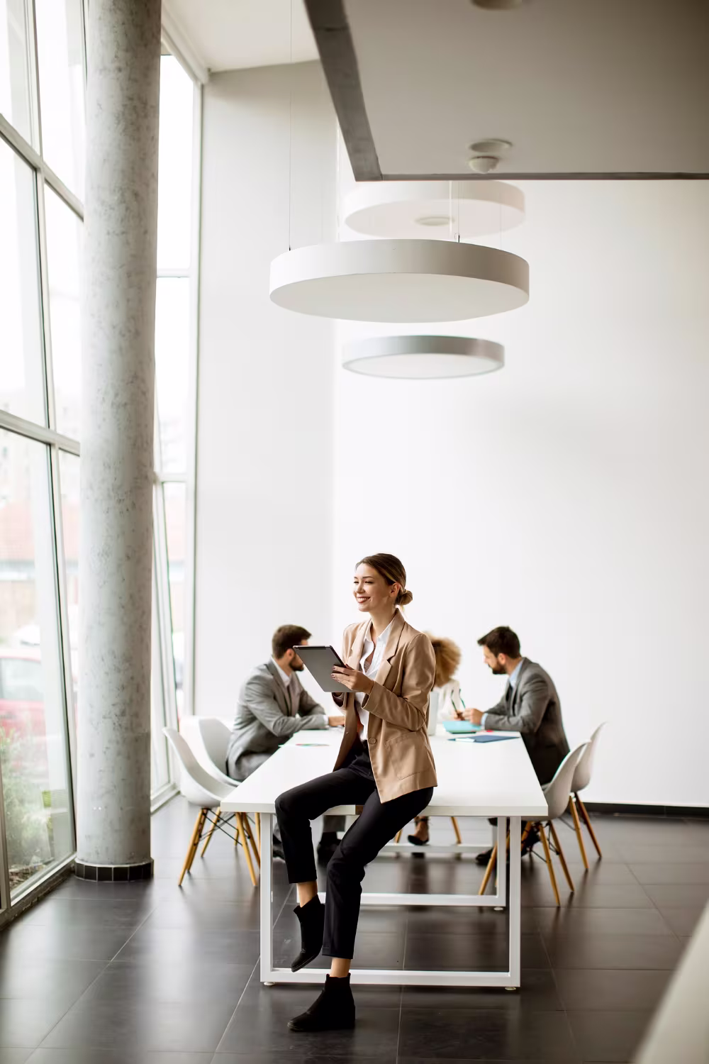 Business consultant with tablet leading a session in a modern meeting room