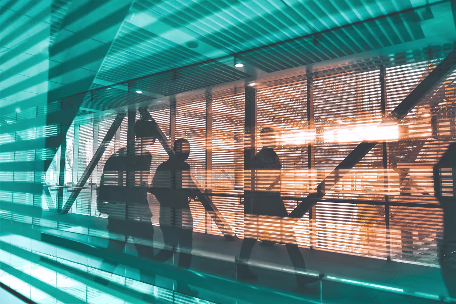 Business professionals in silhouette moving through a modern corporate corridor