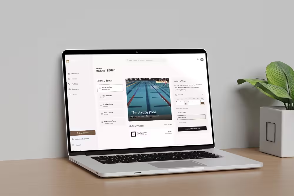 Laptop on desk displaying a reservation system interface for booking spaces and times, featuring a pool image.