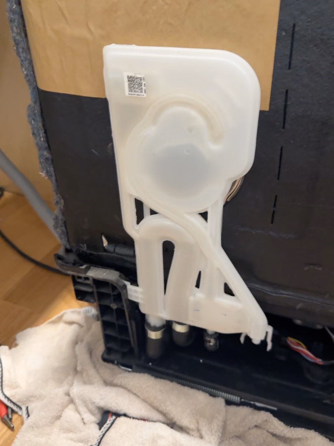 White water-guide assembly and attached hoses exposed at the side of the Samsung dishwasher