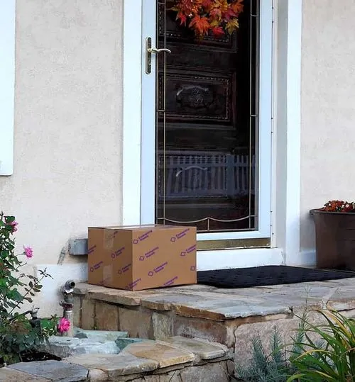 Eine maßgefertigte Packsize-Box, die vor der Haustür eines zufriedenen Kunden steht.