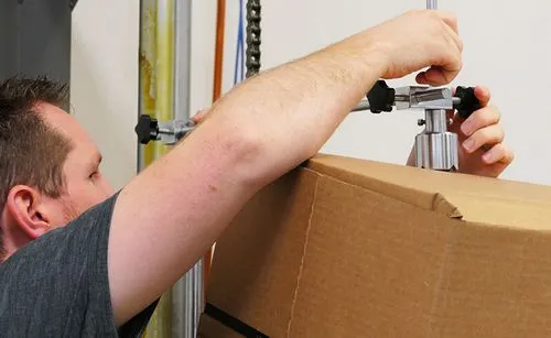 Imagen de un hombre probando la resistencia del borde de una caja de cartón.
