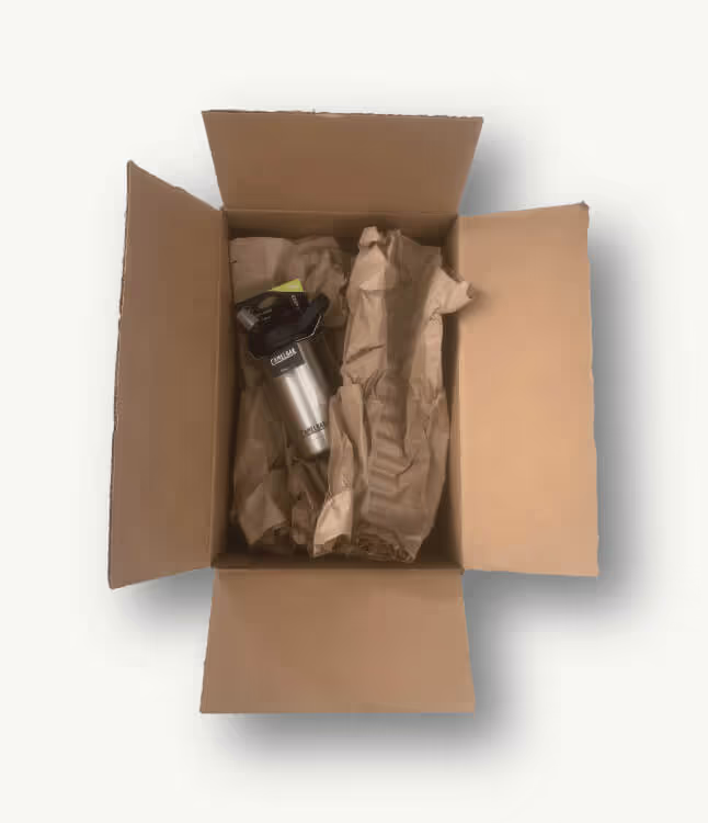 A photo of a poorly packaged water bottle in a cardboard box with wasted space and unnecessary paper filler.