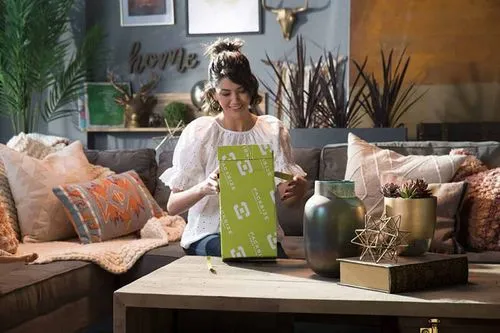 A photo of a woman opening a right-sized box from Packsize.