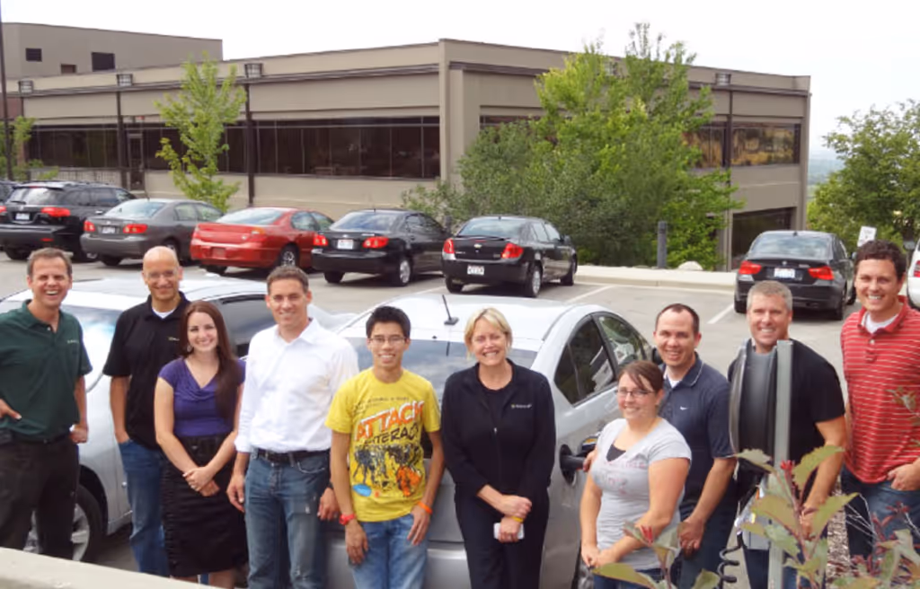 A few Packsize employees celebrating the installation of the first EV charger at the office last year (you can see me in the comparatively loud shirt in the center).