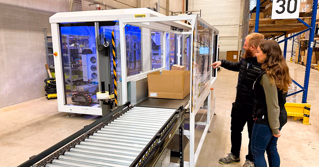 A photo of Artur Bulgarowski (Packsize) & Theodomira Reimer (Loewe) working together for a more automated packaging future.