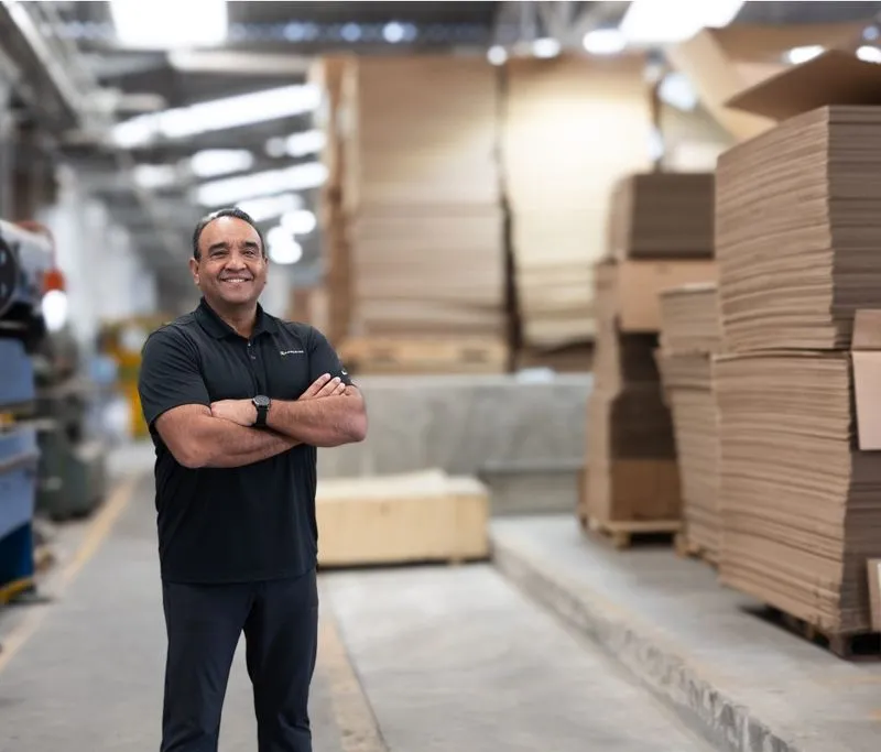 A man stands in front of Packsize corrugated cardboard at Autoparts Tracto.