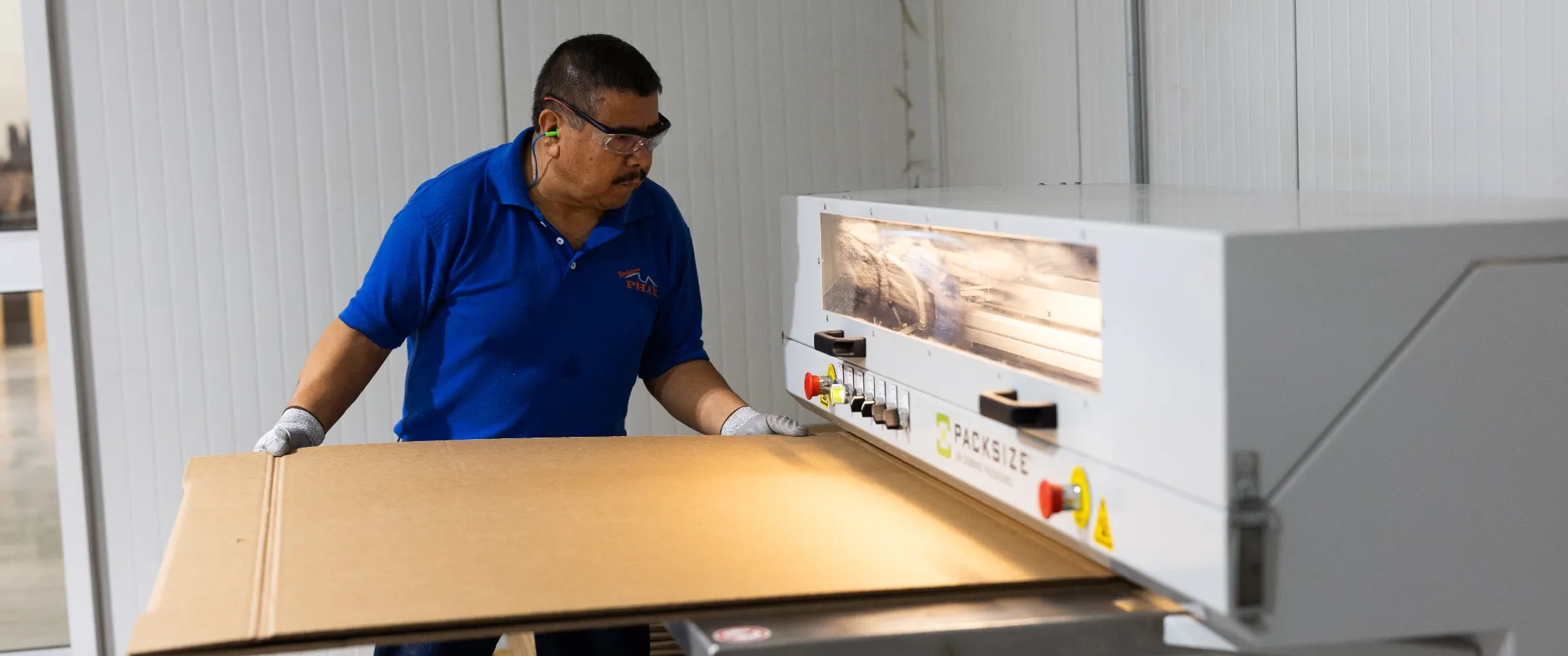 PHAR employee gluing a right-sized Packsize box, preparing it for packing.