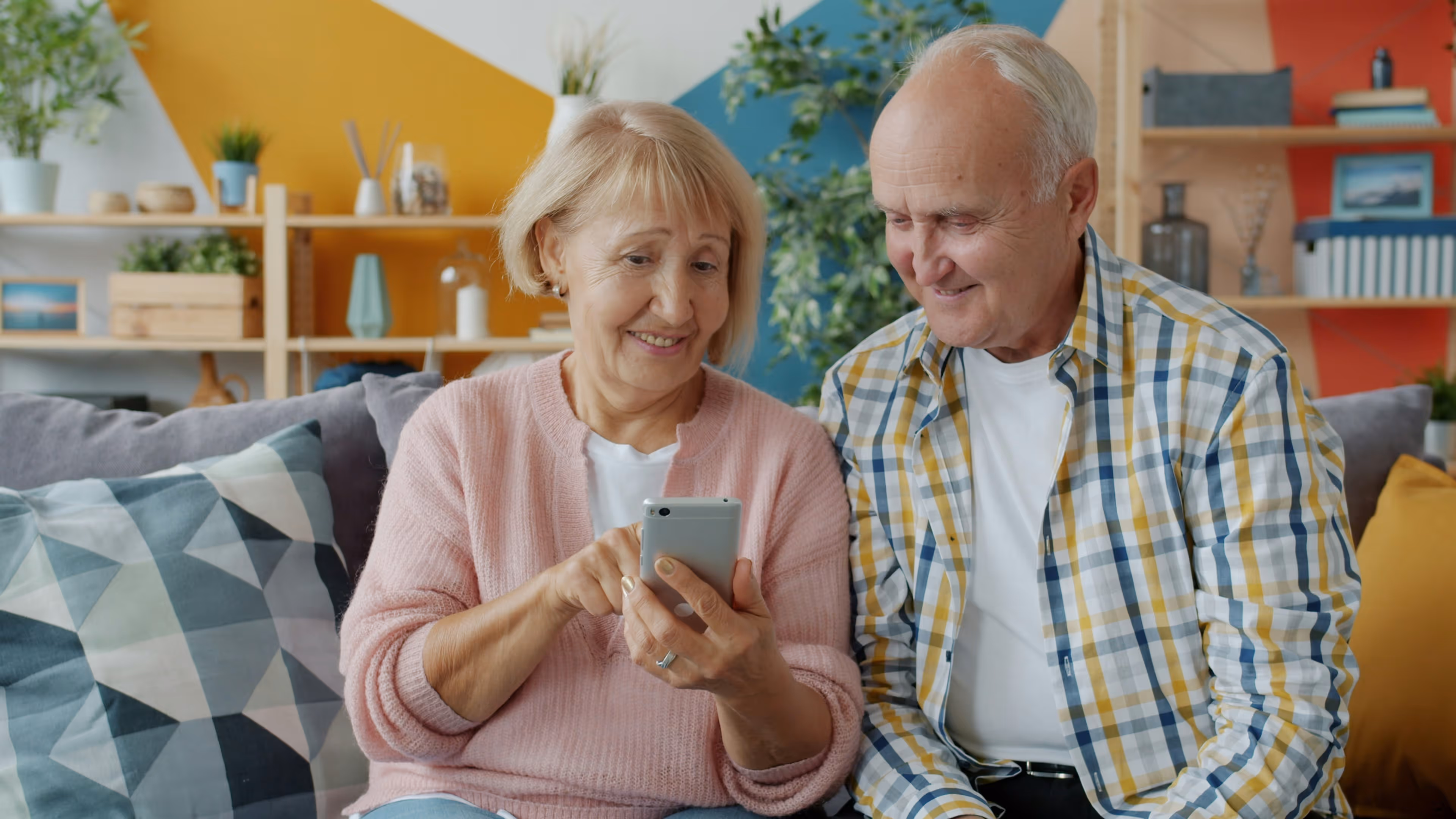 A senior couple enjoying using a mobile device.