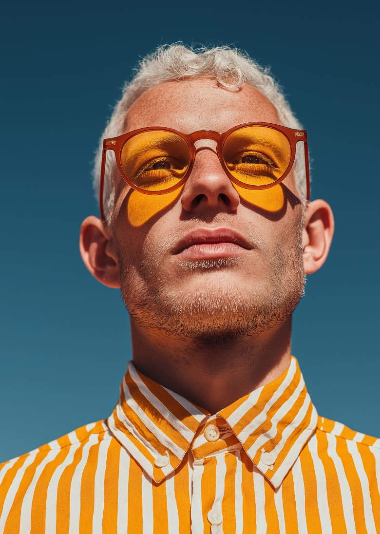 A young man in yellow shirt and yellow sunglasses. 