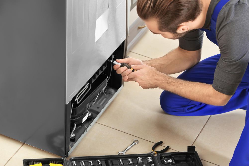`Technician repairing a refrigerator`