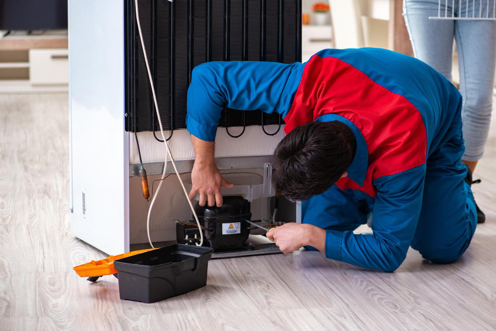 Technician repairing a refrigerator compressor