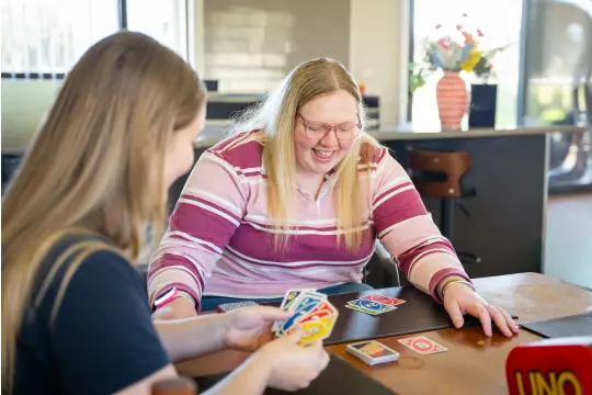 Disability client playing cards with care worker