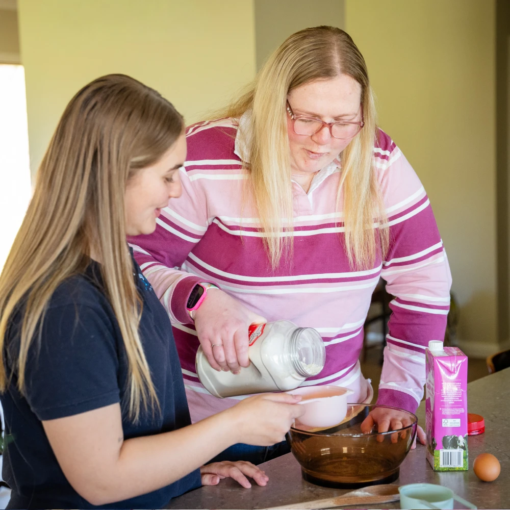 Disability client at home getting assistance with meal preparation