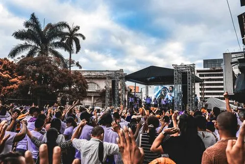 Lively crowd raising their hands toward a stage