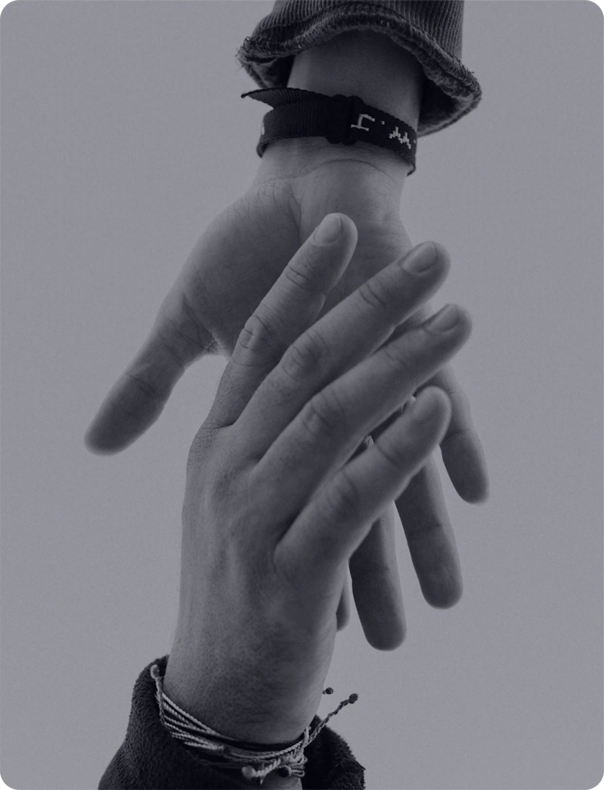Two hands gently holding each other in black and white.