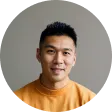 A man in a yellow shirt is looking at the camera.
