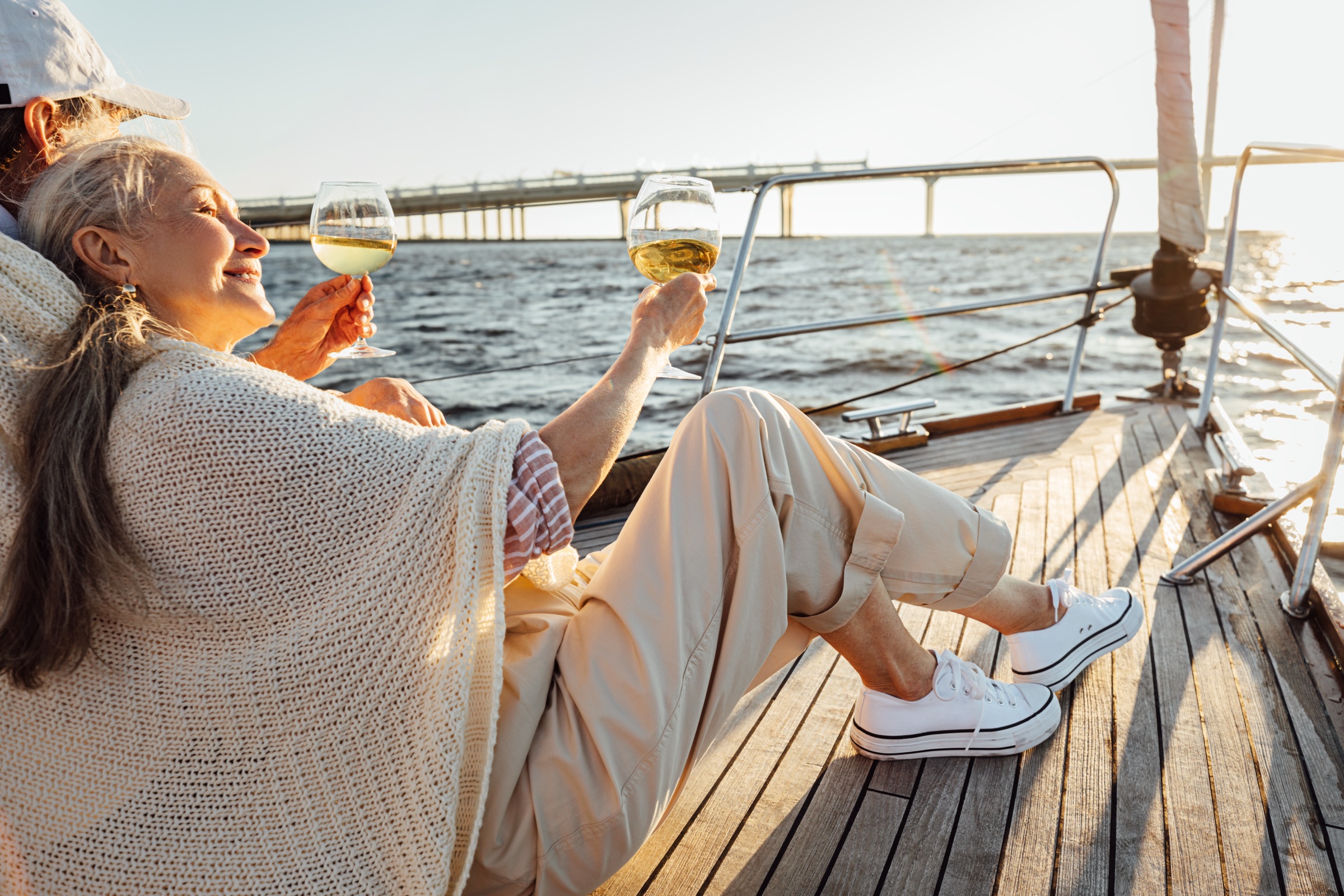 A couple raising wine glasses on a yacht deck