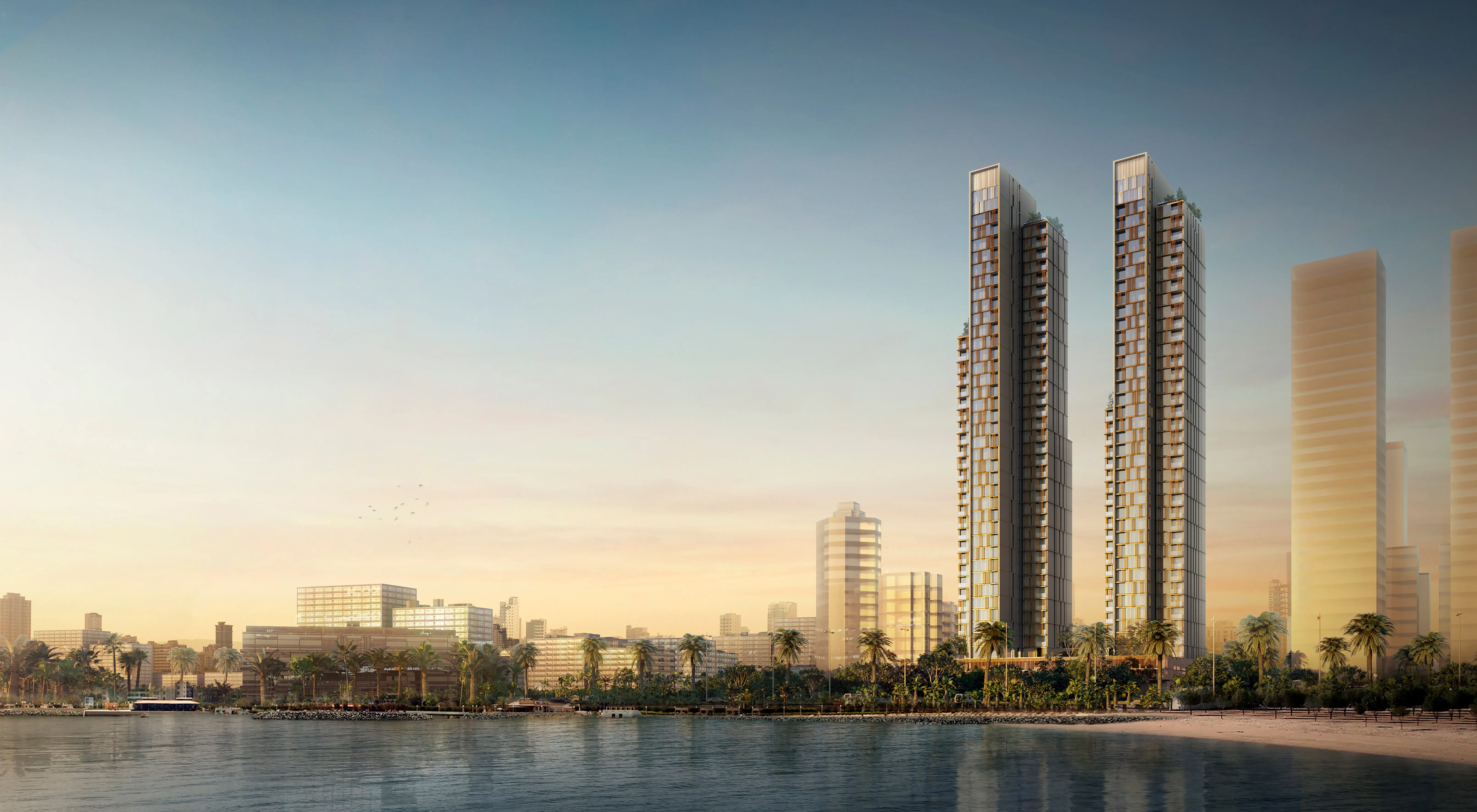 Twin high-rise towers of Hessah Al Mubarak rising above a palm-lined waterfront in Kuwait City at dusk, with the wider city skyline beyond