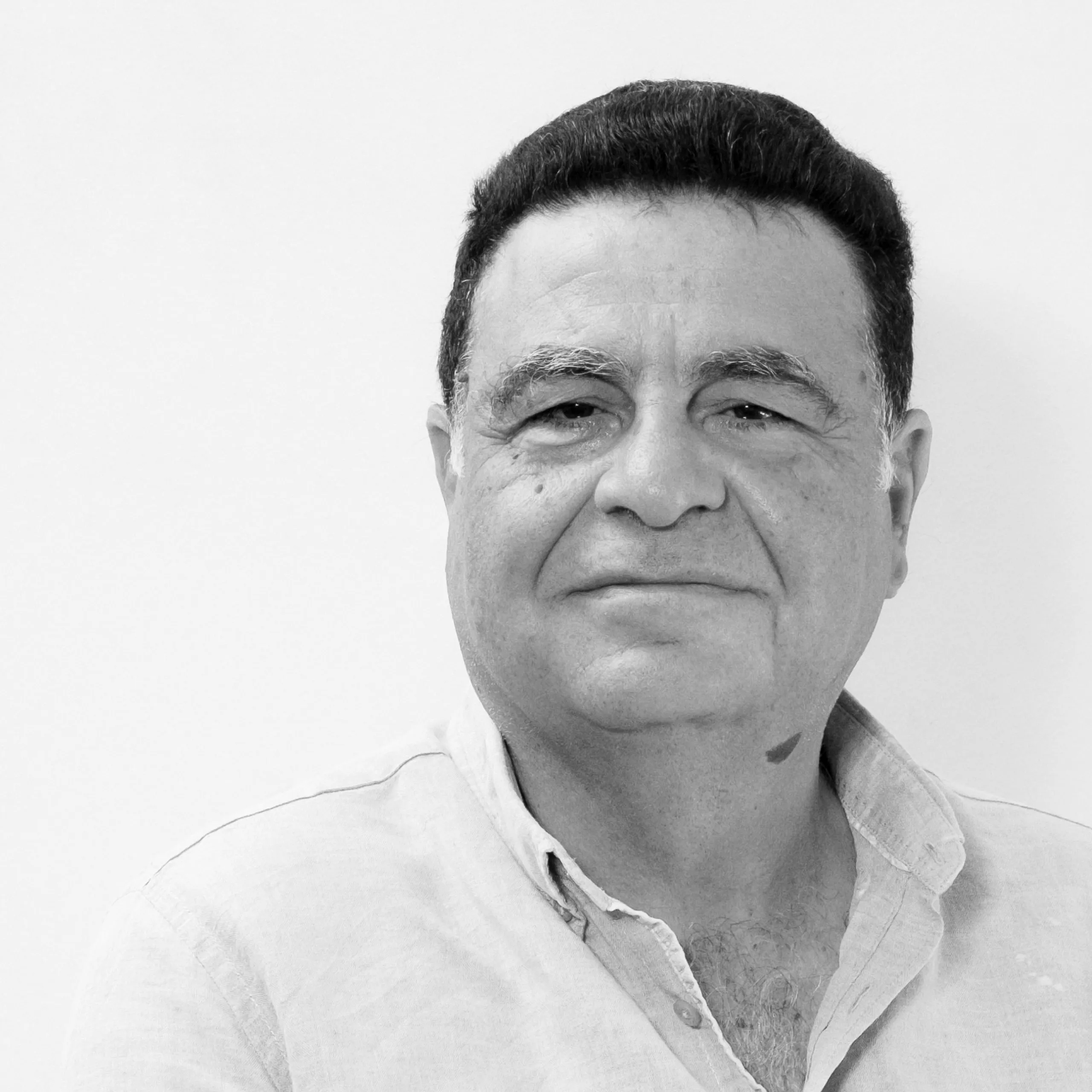Joseph Fadel, Lead Architect at Nabil Gholam Architects, black and white portrait in an open-collared linen shirt against a plain background