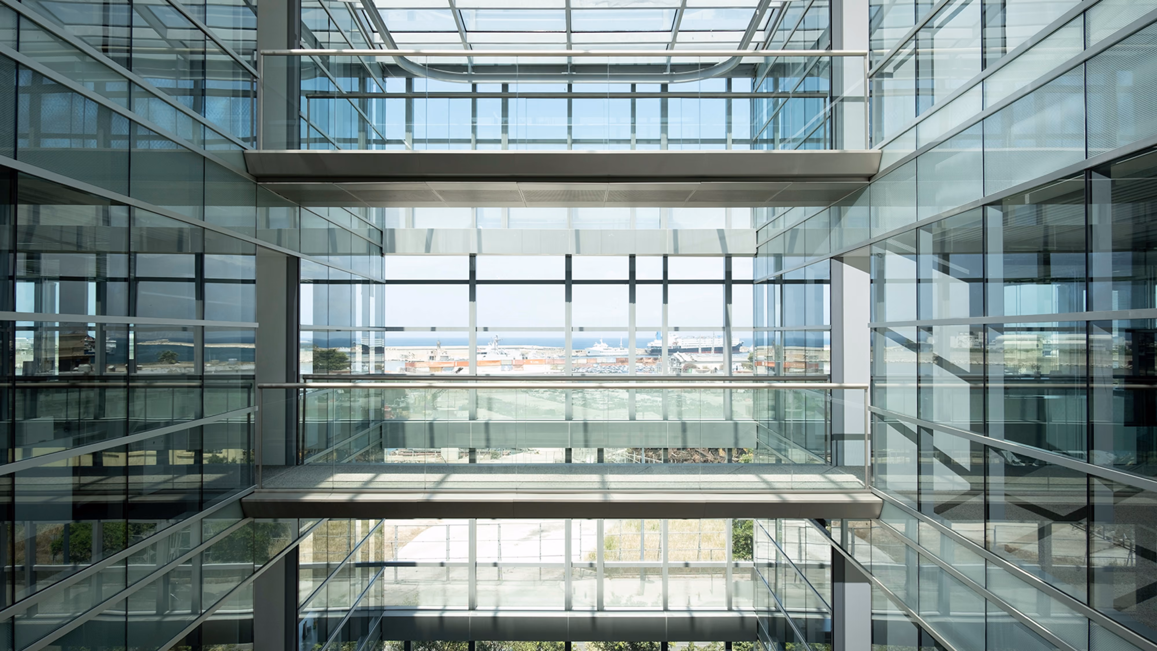 CMA-CGM Headquarters refurbishment in Beirut, Lebanon, by Nabil Gholam Architects, glazed atrium with floating glass bridges framing a distant sea view