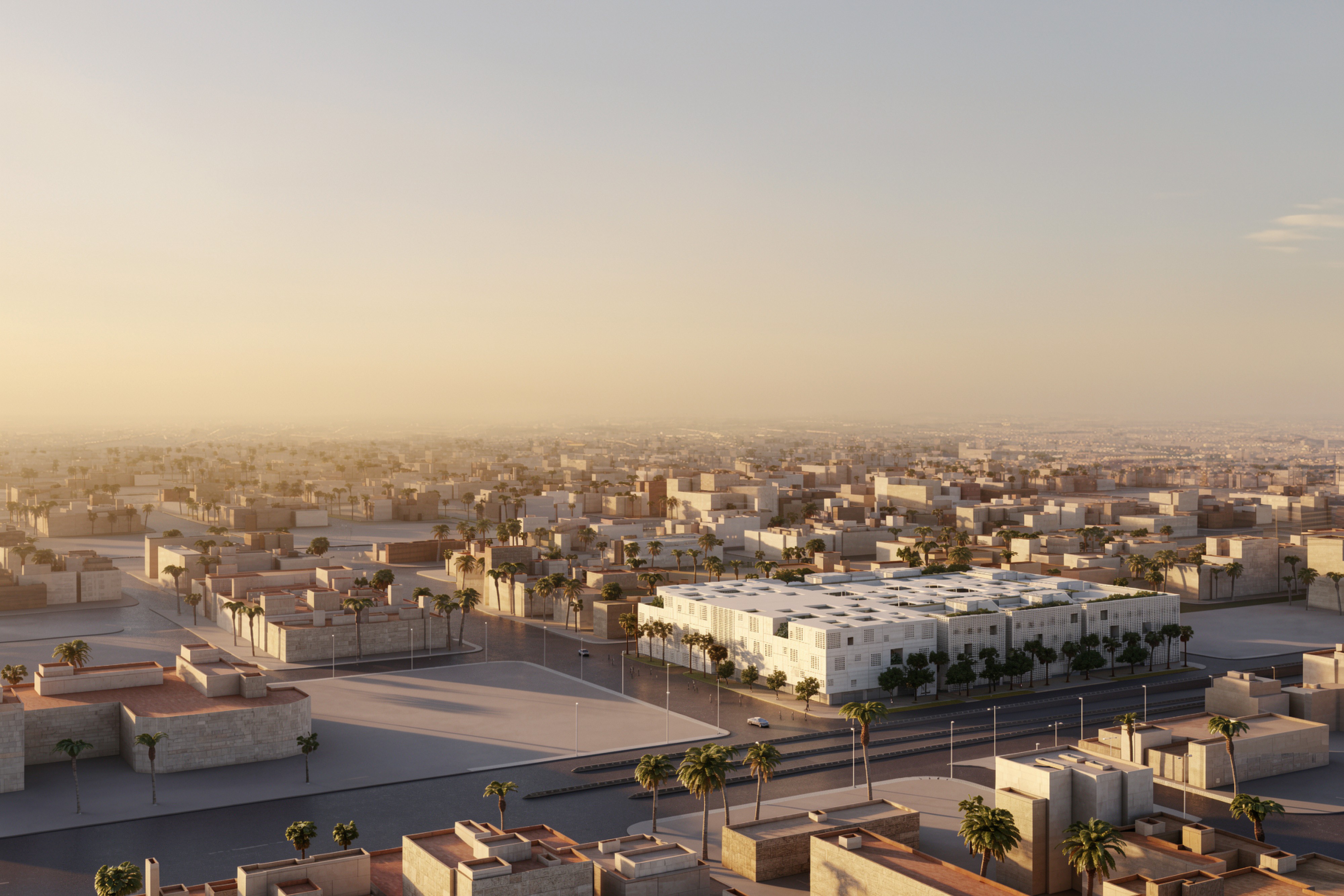 Aerial view of Art Oasis in Riyadh, a low-rise white perforated concrete complex amid the desert city at sunset, surrounded by palm trees and low buildings
