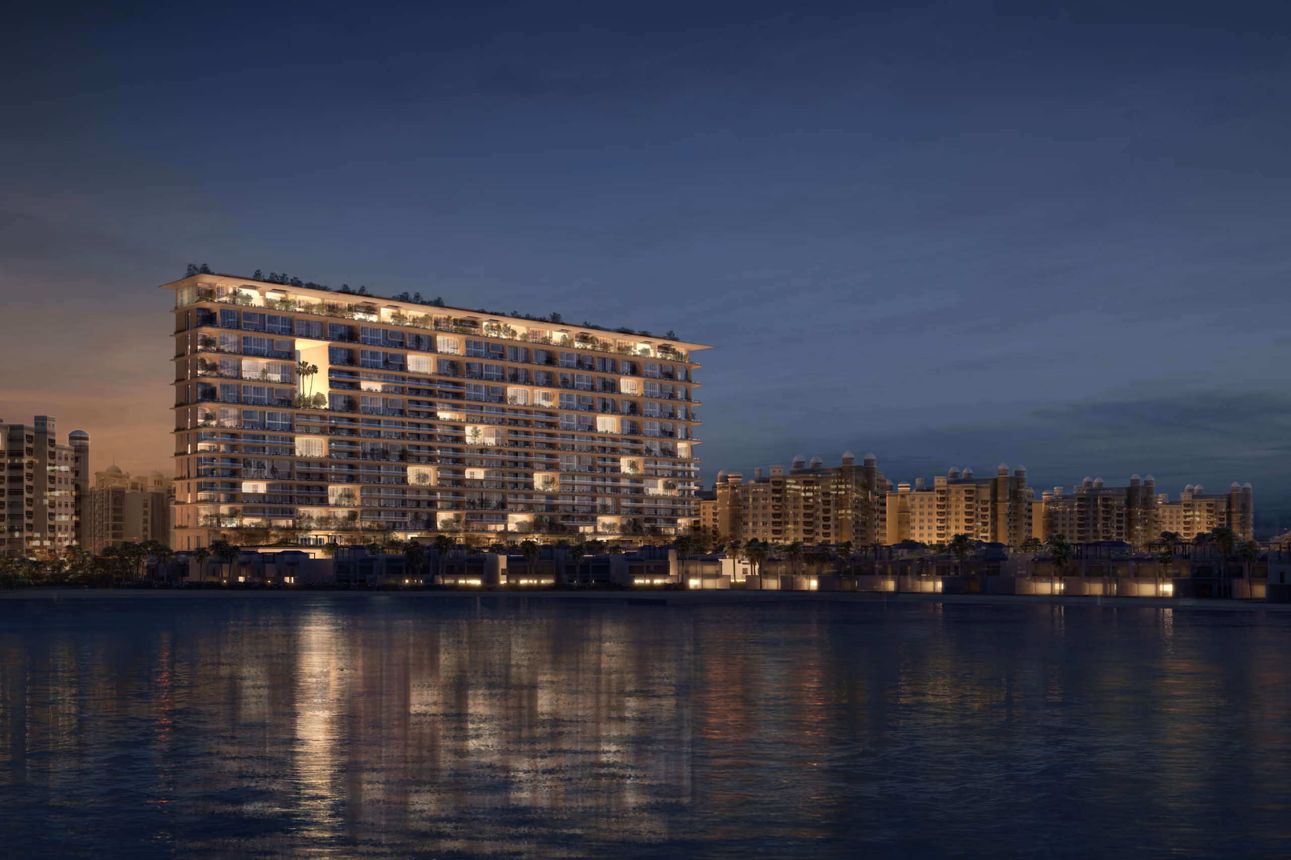 Skylife residential tower in Dubai lit up at dusk, tiered balconies and terraces reflected in the calm waters of Palm Jumeirah