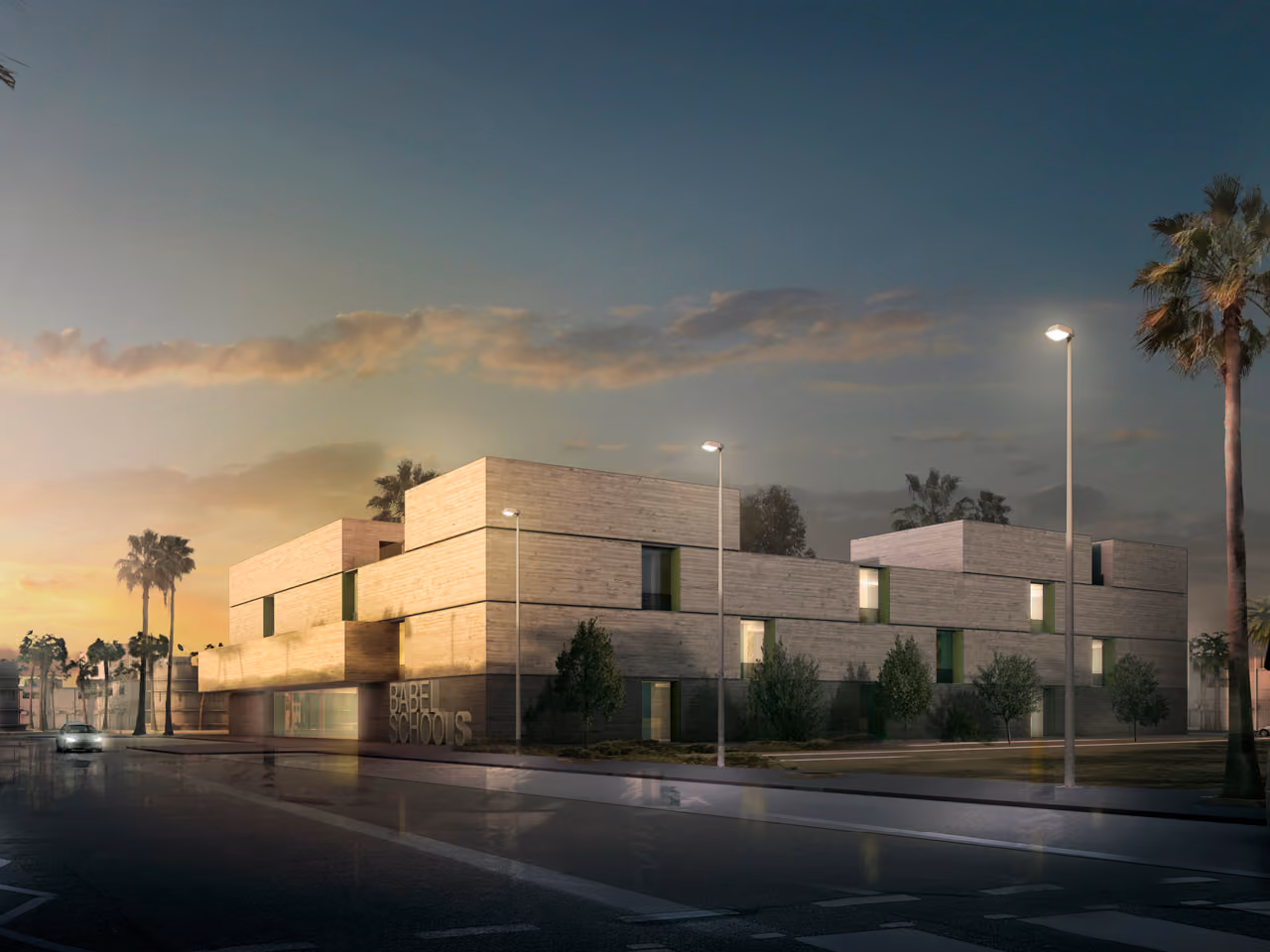 Babel Schools in Babel at dusk, a stone-clad three-storey building with green accents, illuminated street lamps and palm trees lining the road