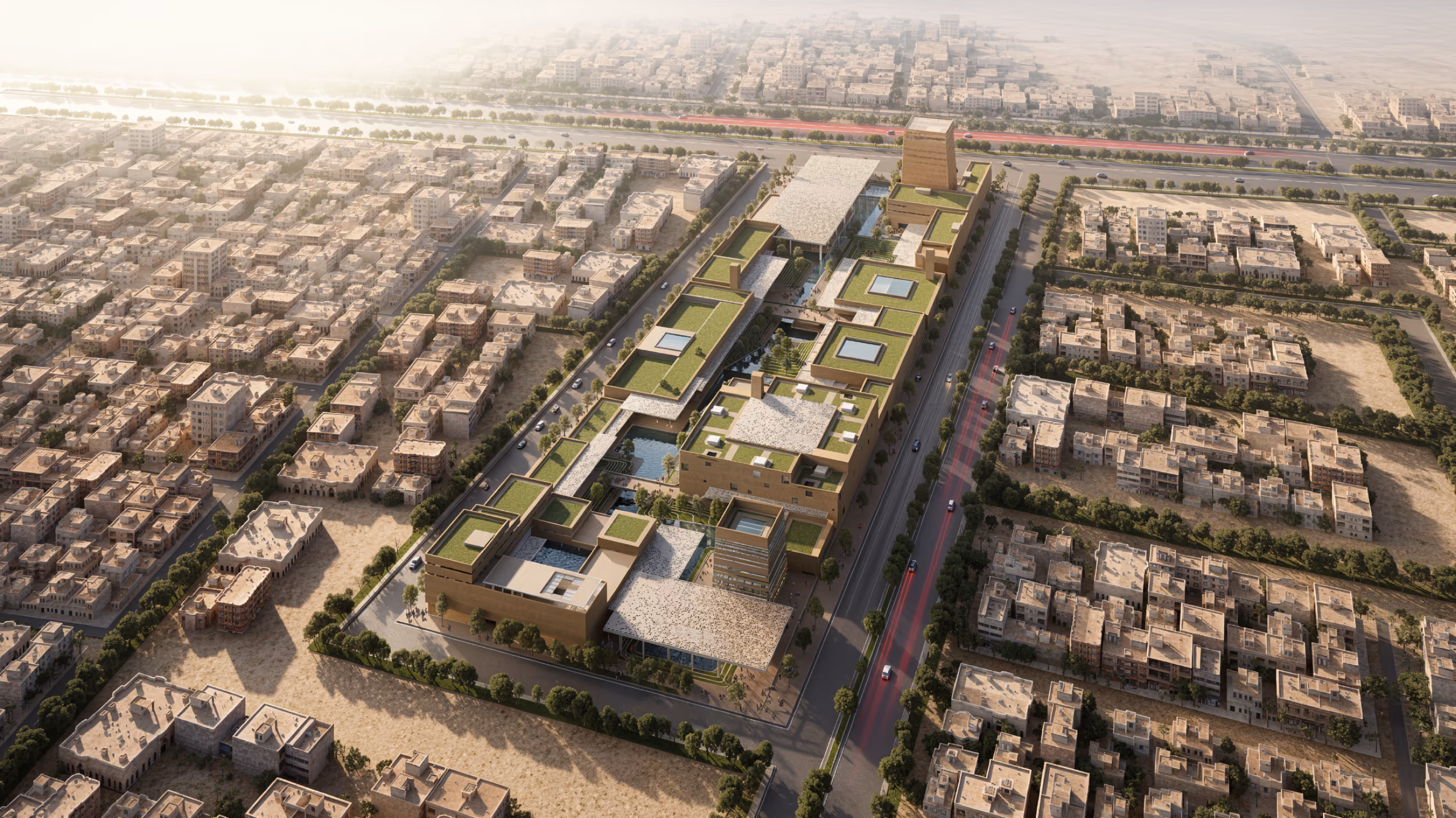 Aerial view of Green Office Park, showing terraced green roofs and a slender tower along a linear pedestrian spine amid dense low-rise city fabric