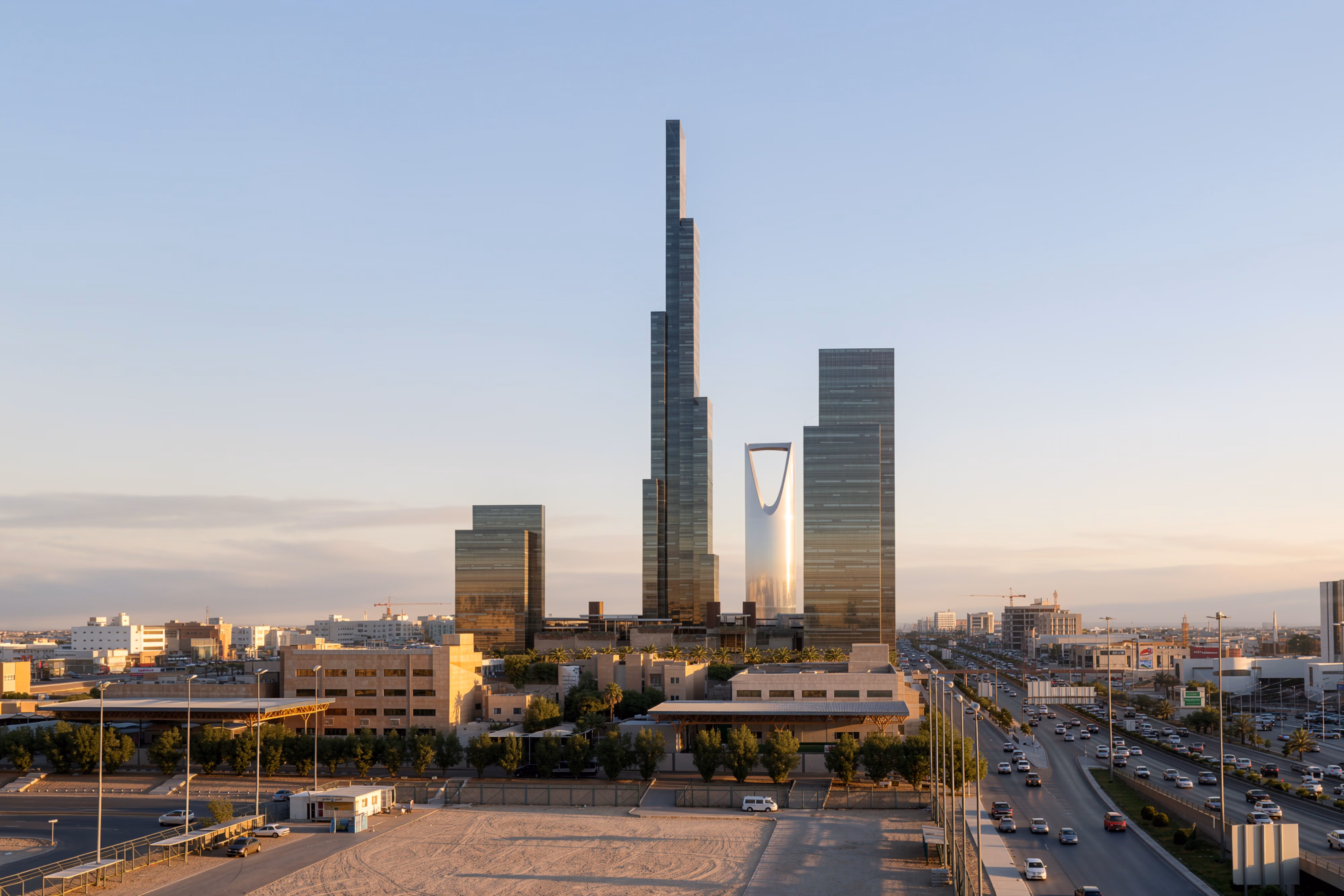 Mixed-Use Development in Riyadh by Nabil Gholam Architects, a tapering high-rise tower rising above lower glass buildings beside a busy highway at dusk