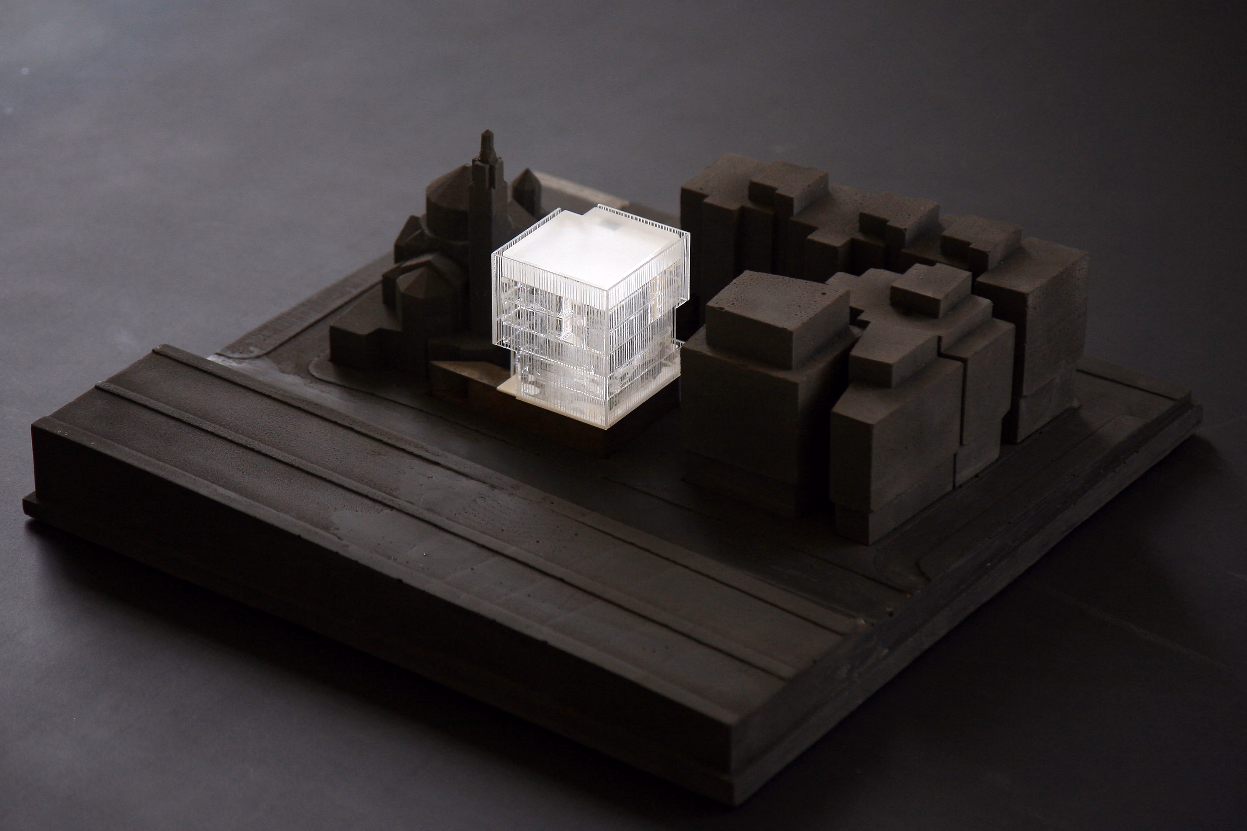 Study model of Saifi 178 in Beirut, a translucent illuminated cube volume set among dark surrounding building blocks on a textured site base