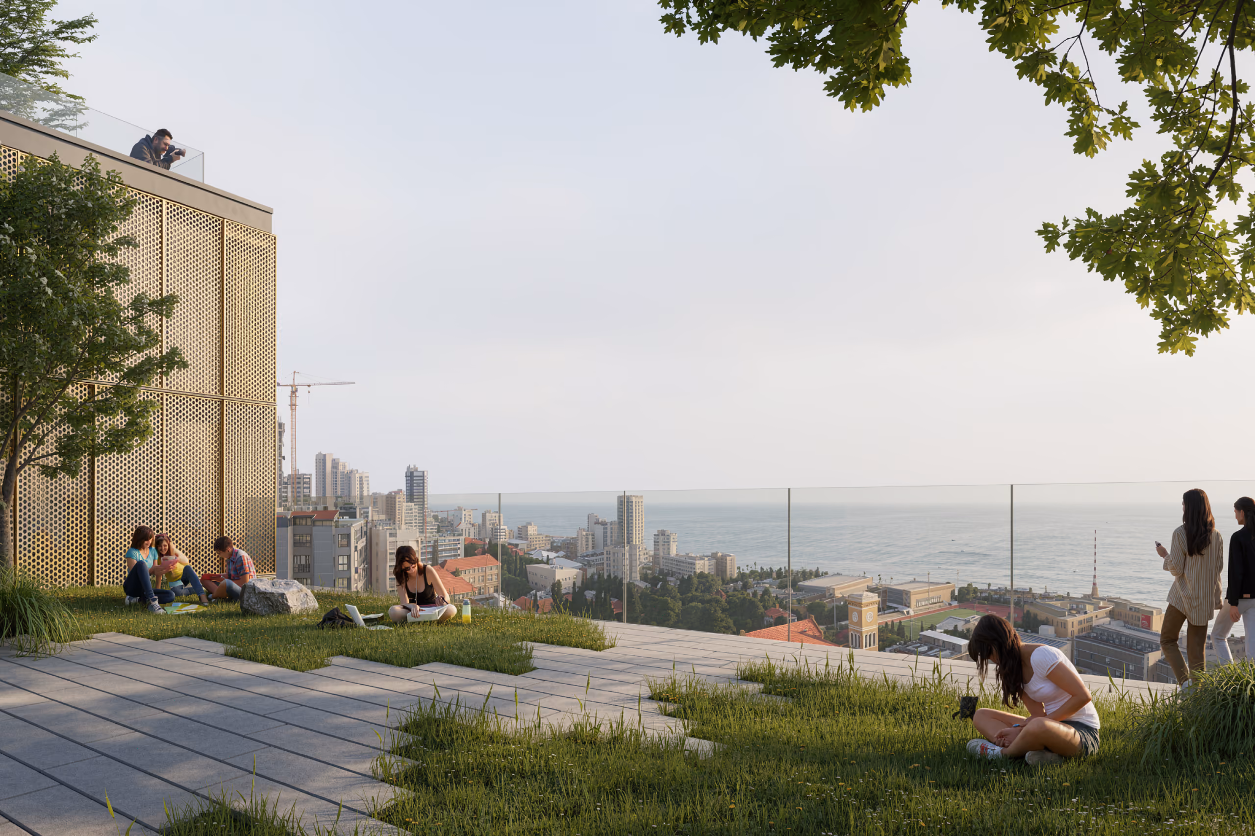 Rooftop terrace of City Campus 01 in Beirut, students relaxing on grass and paving under trees with a perforated gold facade and coastal skyline view