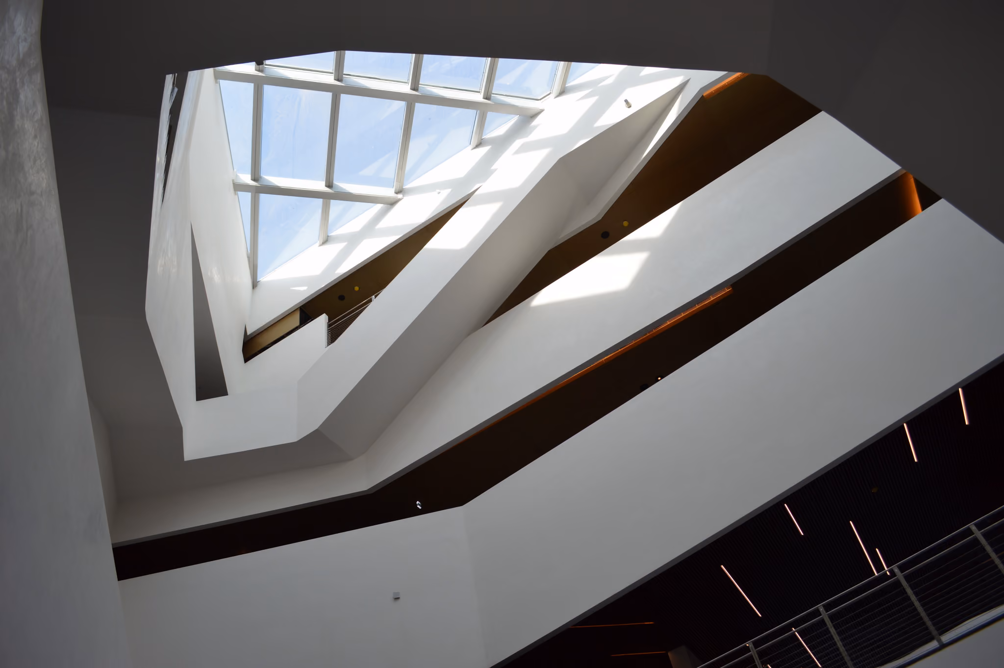 Interior atrium of Beirut Marina & Town Quay in Beirut, angular white skylight and faceted ceiling planes lit by daylight above layered balconies