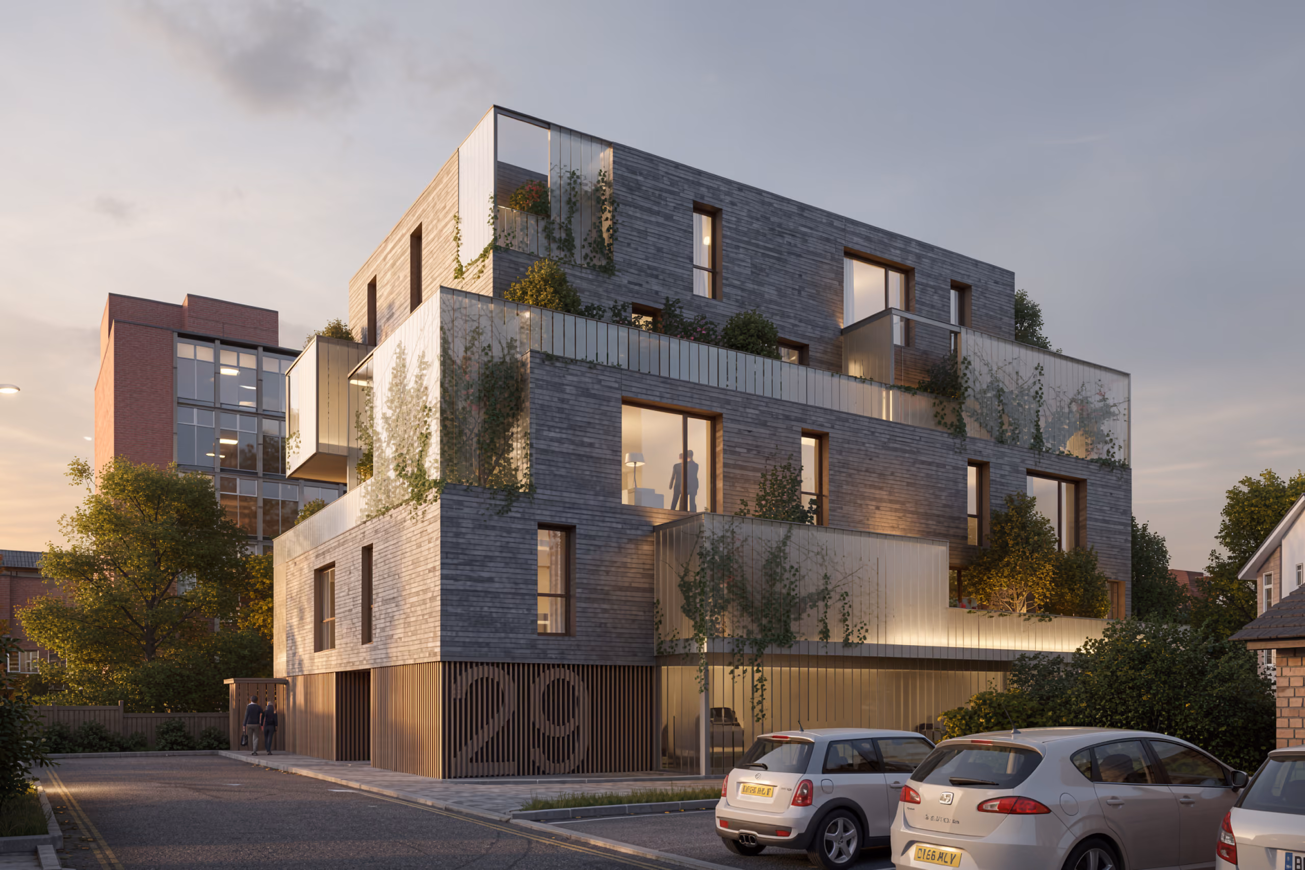 Wicks Place in Chelmsford, a brick-clad residential building with staggered glass-fronted terraces covered in climbing plants, at dusk
