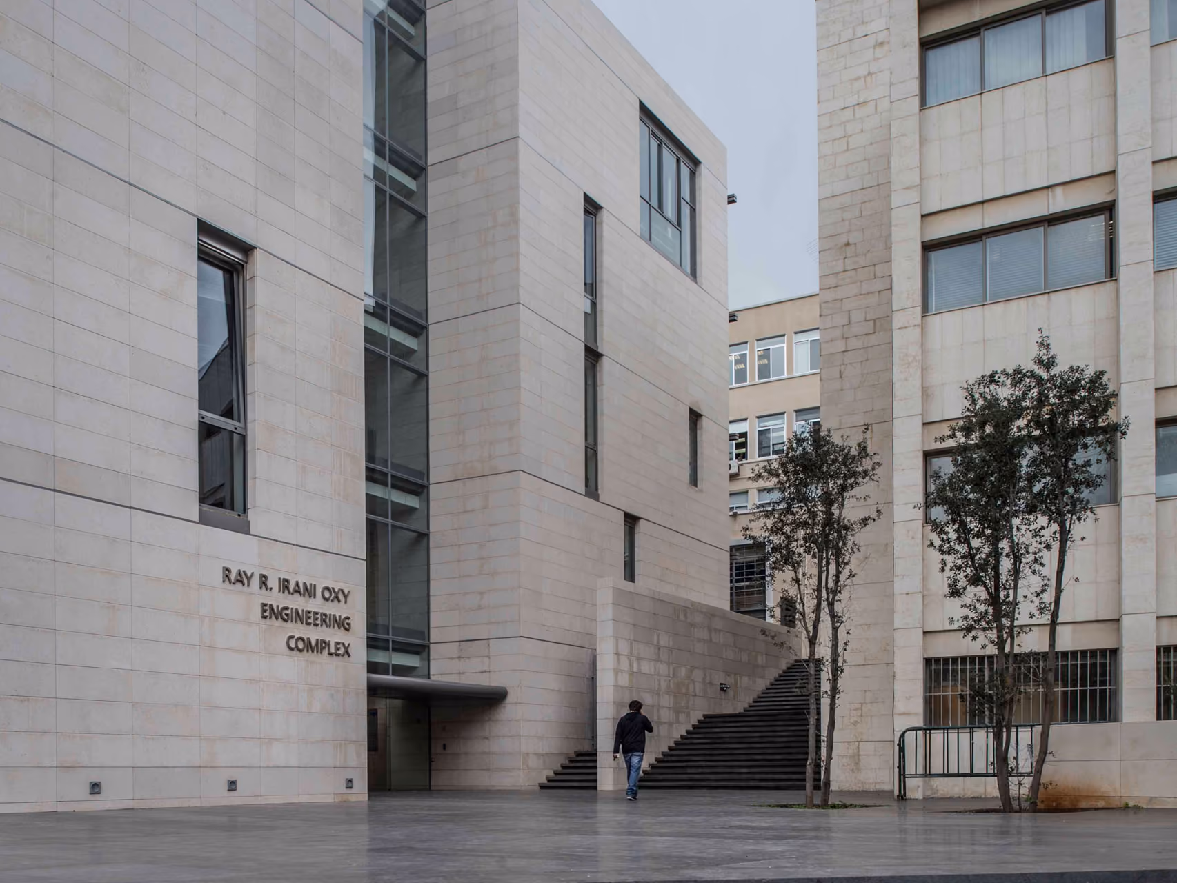 Stone-clad entrance to the Ray R. Irani Oxy Engineering Complex at AUB IOEC Engineering Labs in Beirut, with steps leading between two ribbon-like volumes