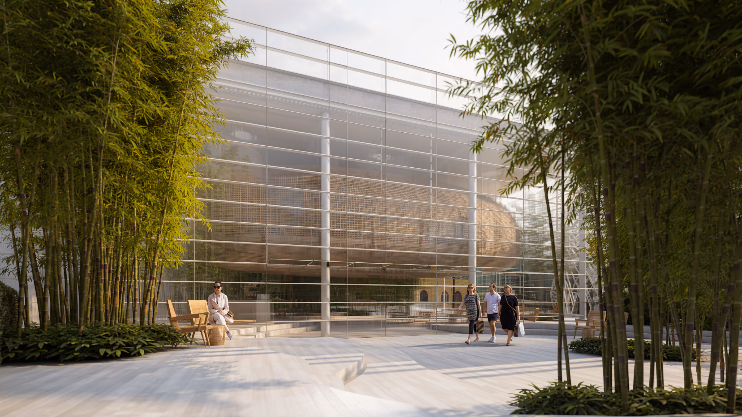Bamboo-lined plaza at Art Hub in Beirut, visitors walking past a glass-screened floating volume with a woven pod-shaped structure visible inside