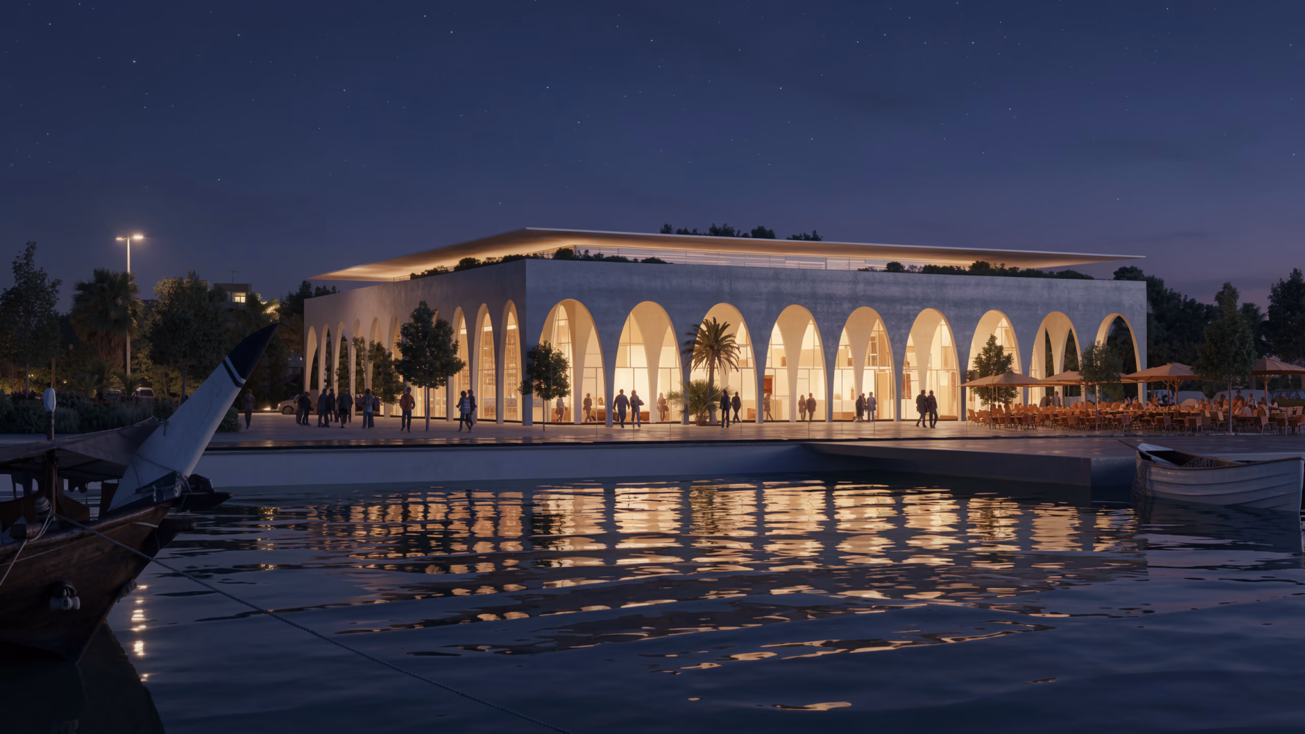 Fish Market in the Arabian Peninsula, illuminated arcaded pavilion glowing at night, reflected in the harbour water beside moored boats